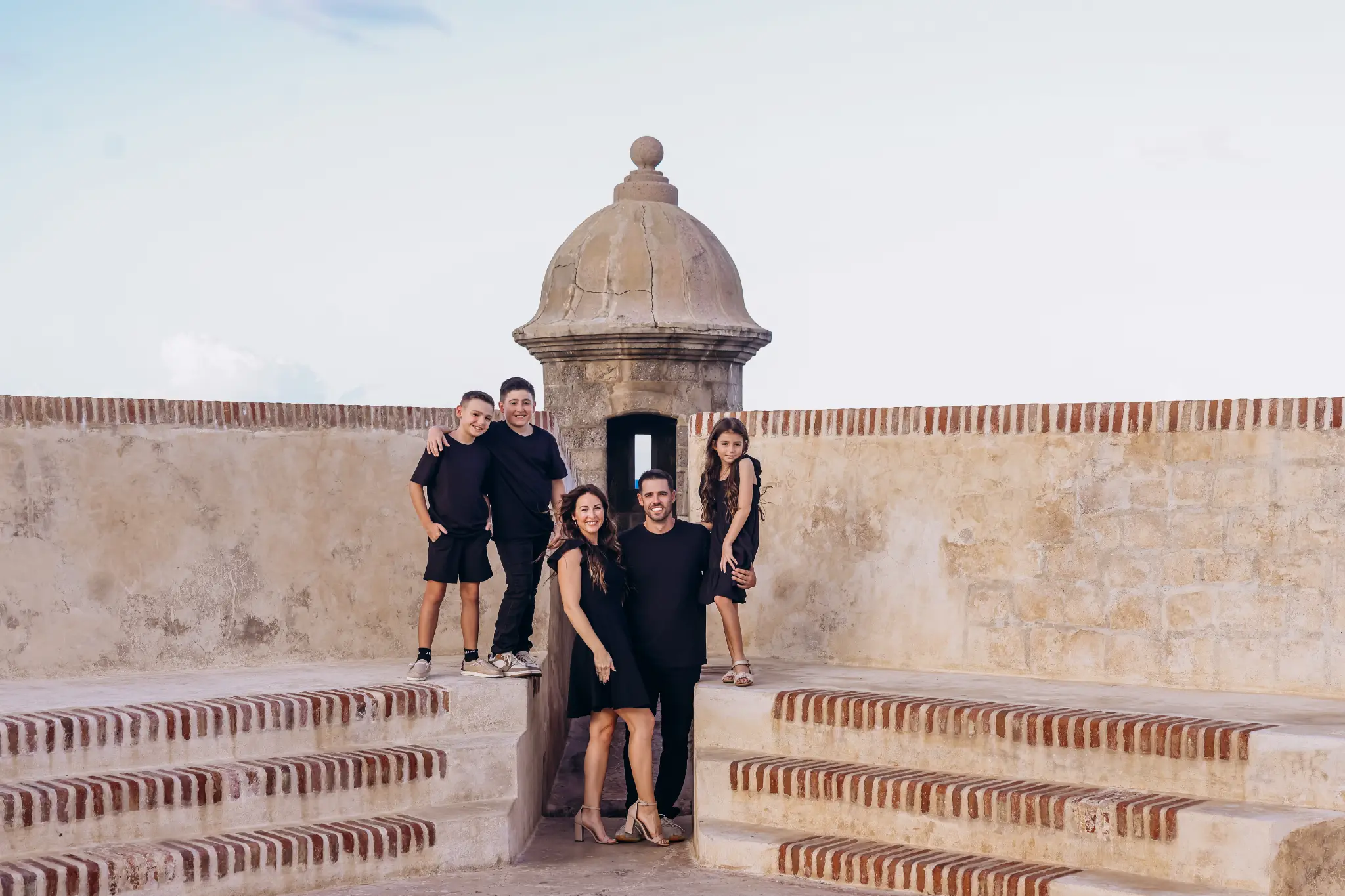 Family gathered on historic stone steps near El Morro in Old San Juan, Puerto Rico, photographed by Olga Thomas