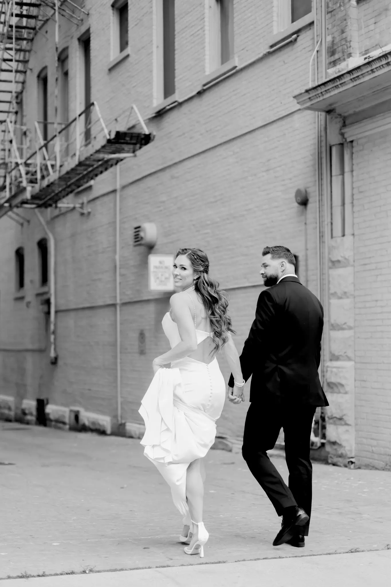 Wedding couple walking together past historic urban architecture