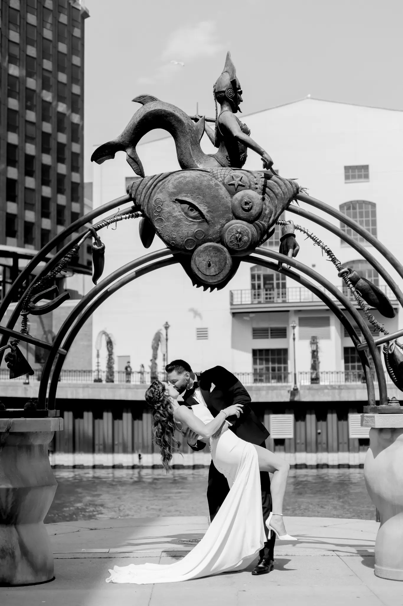 Black-and-white wedding couple beneath an ornate decorative gate