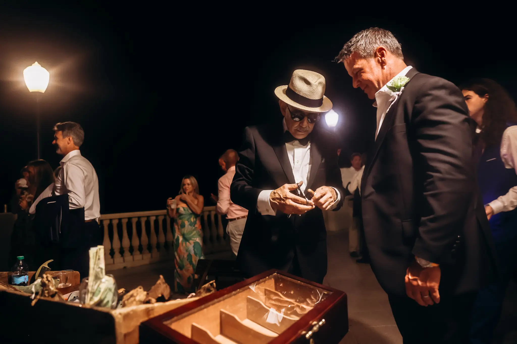 Wedding guests gathered around a late-evening reception table