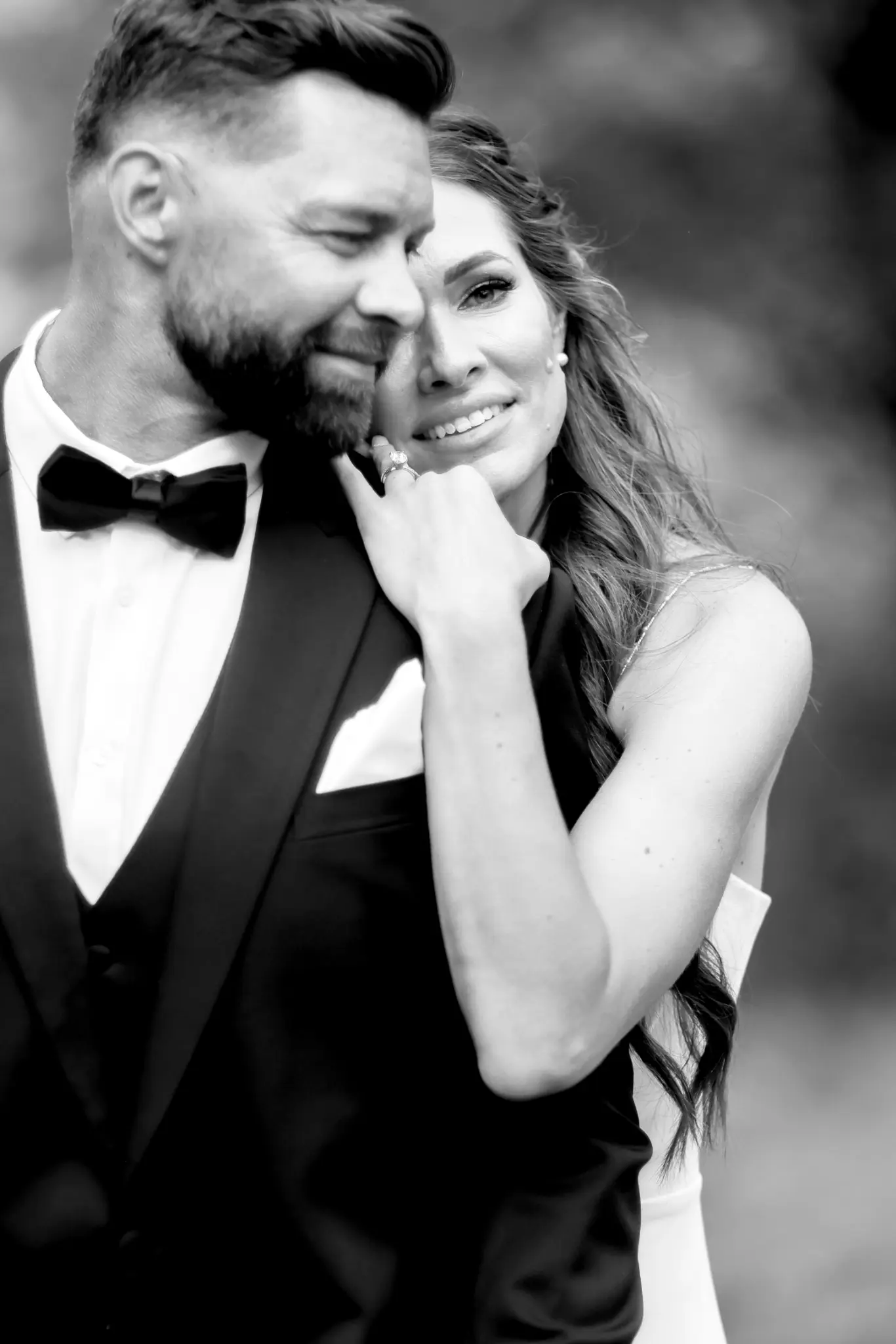 Black-and-white close portrait of a wedding couple in formal attire