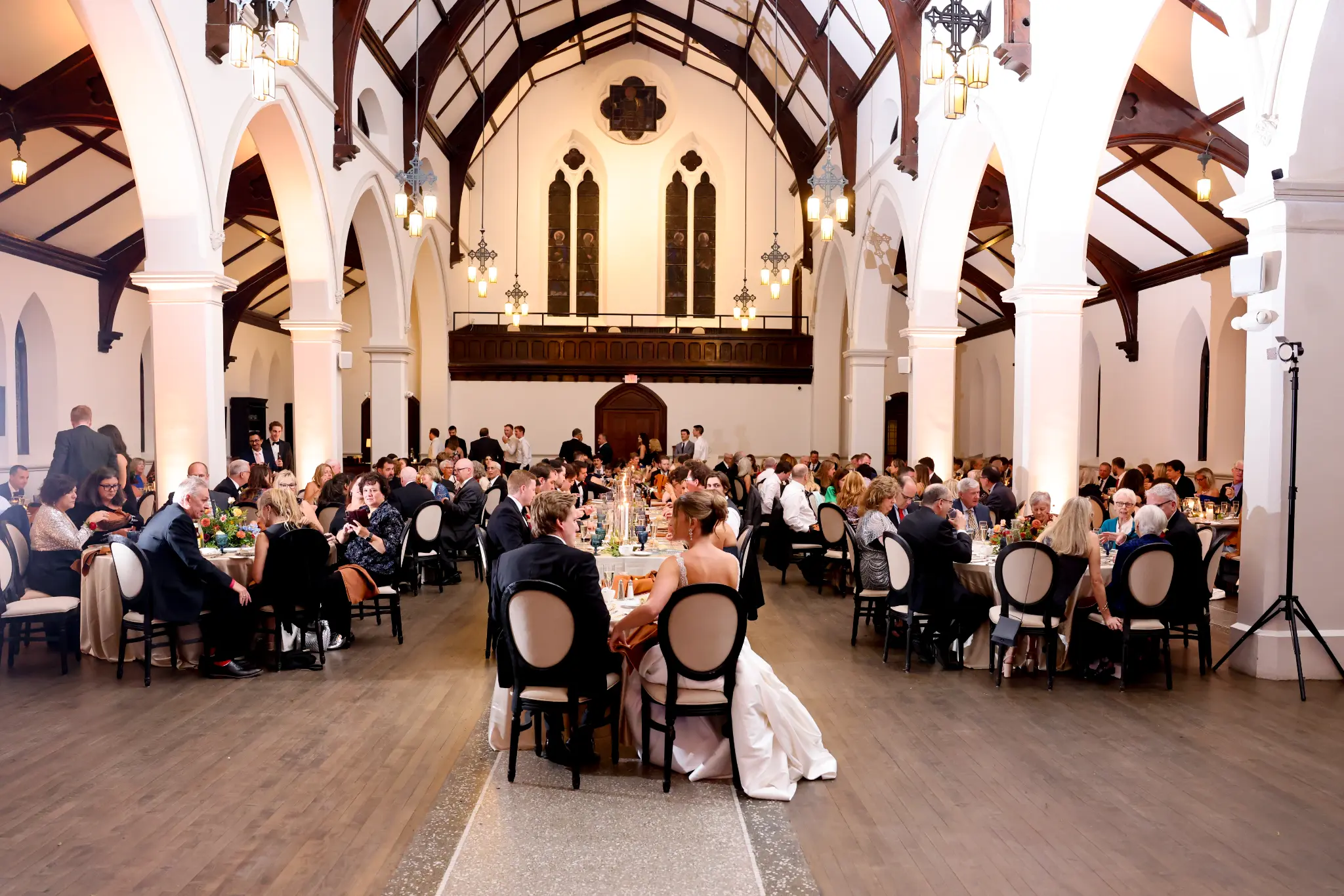 Wide church-like wedding reception space with a couple dancing