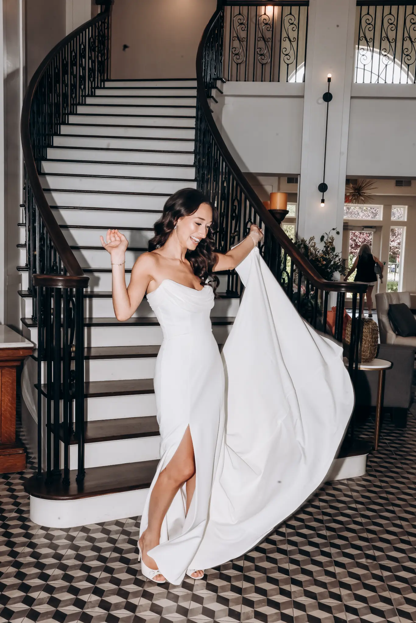 Bride lifting her gown on steps beside a historic building