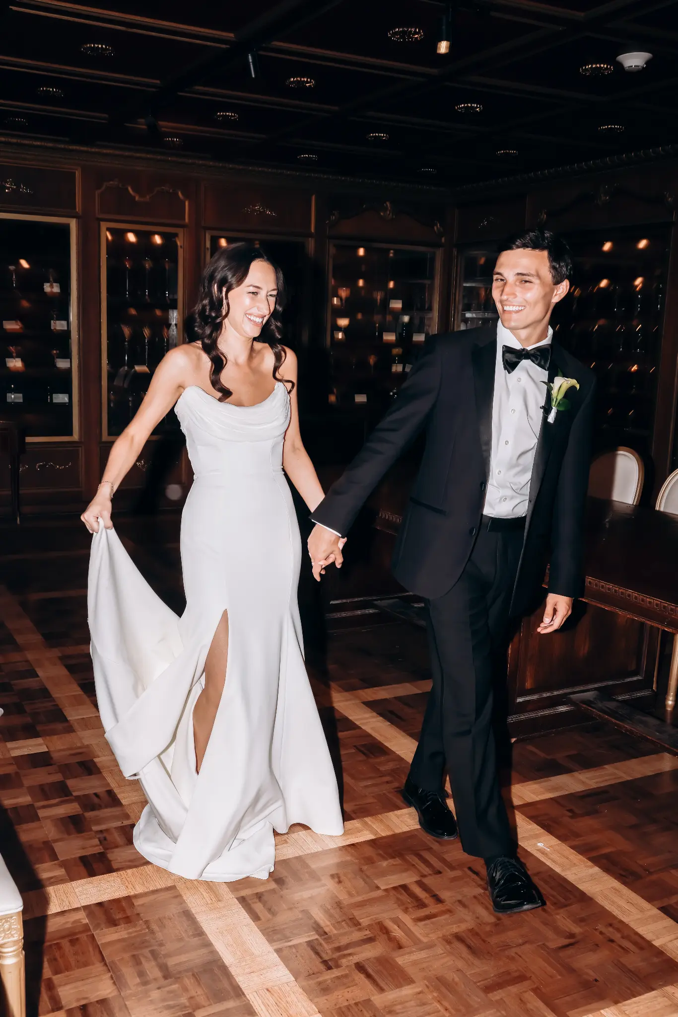 Bride and groom walking into a reception space with twinkle lights