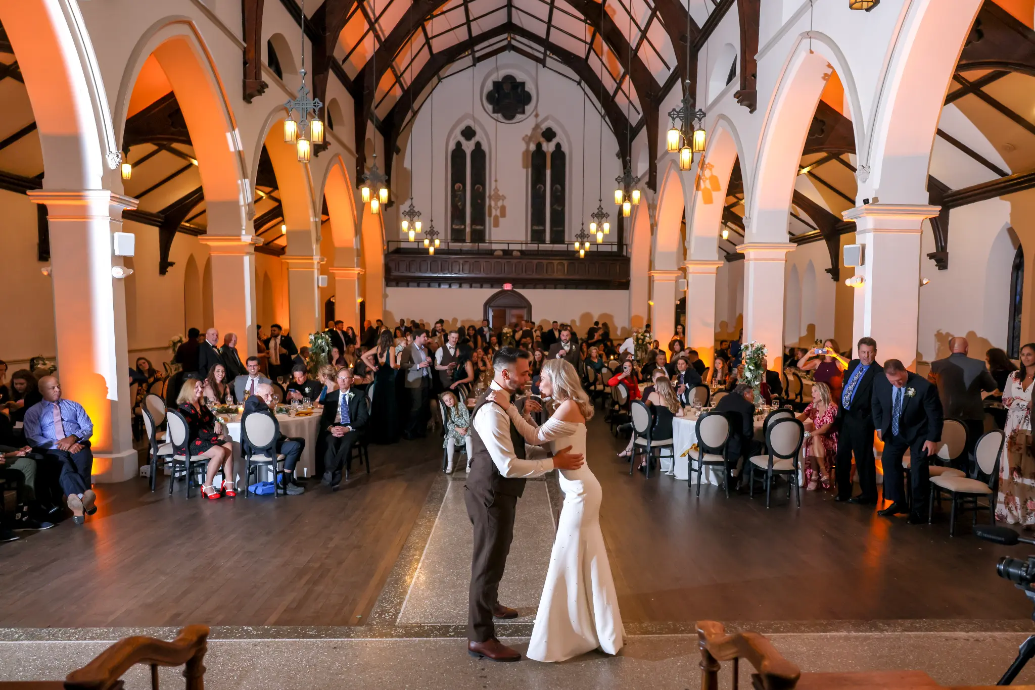 Bride and groom dancing in a grand church-like wedding reception hall