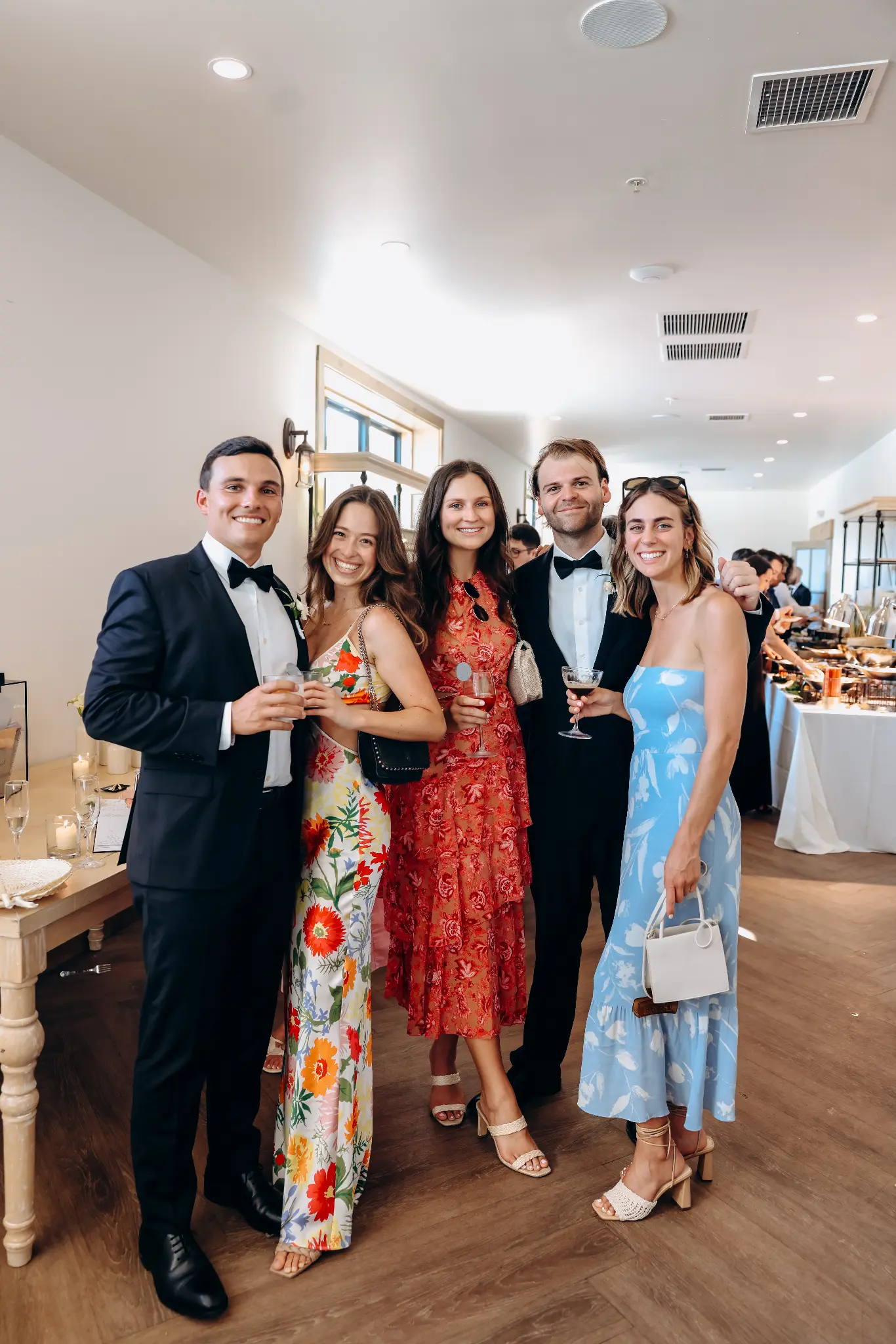 Dressed-up wedding guests posing together at an indoor reception
