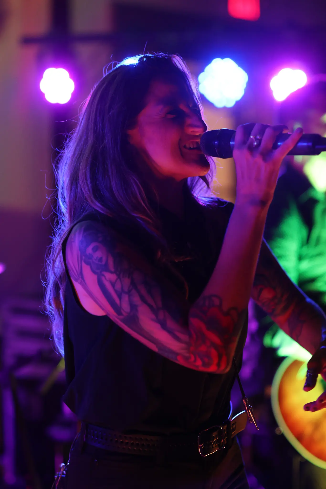 Singer performing at a wedding reception beneath purple lighting