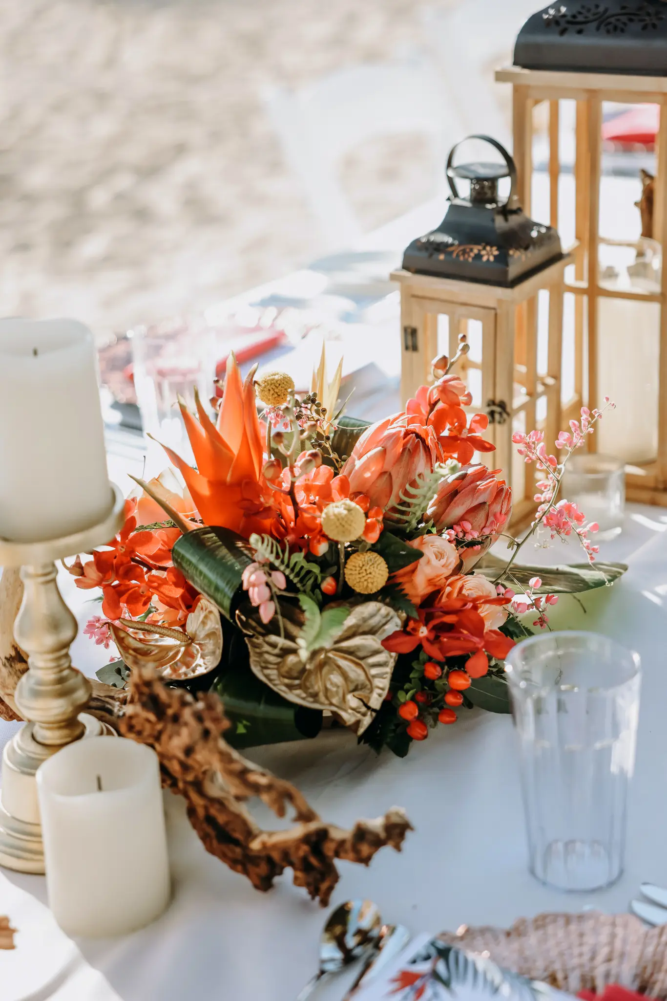 Bright floral arrangement and lantern on a wedding reception table