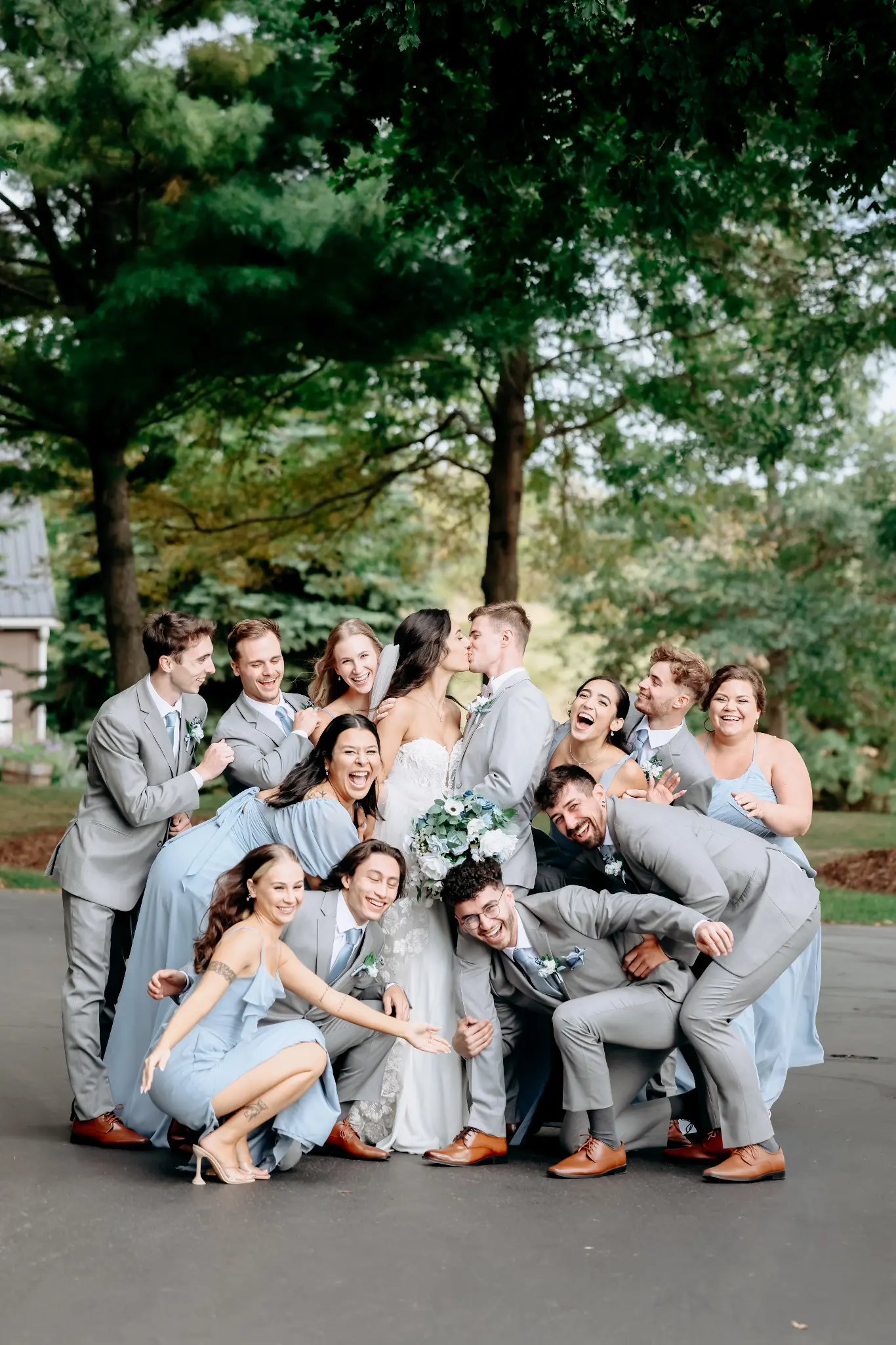Wedding party seated together beneath a large tree