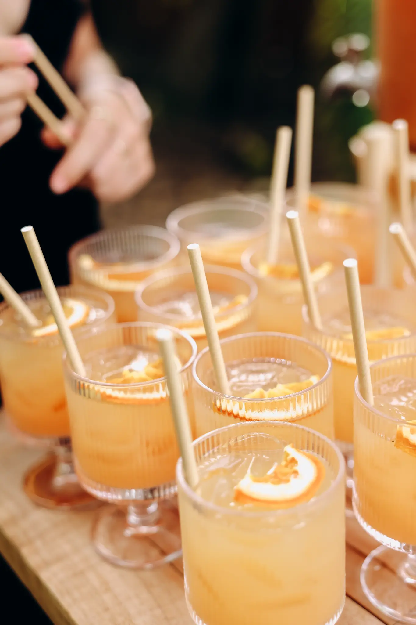 Orange cocktails with straws arranged on a wedding reception table