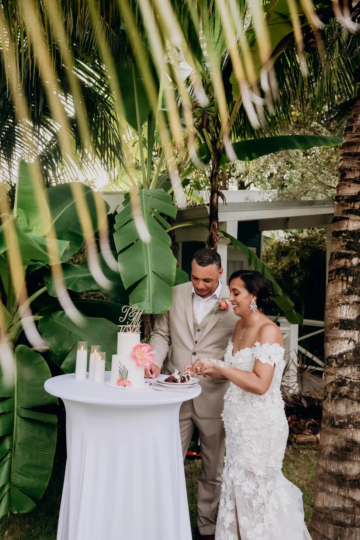 Bride and groom cutting their wedding cake at a small outdoor table