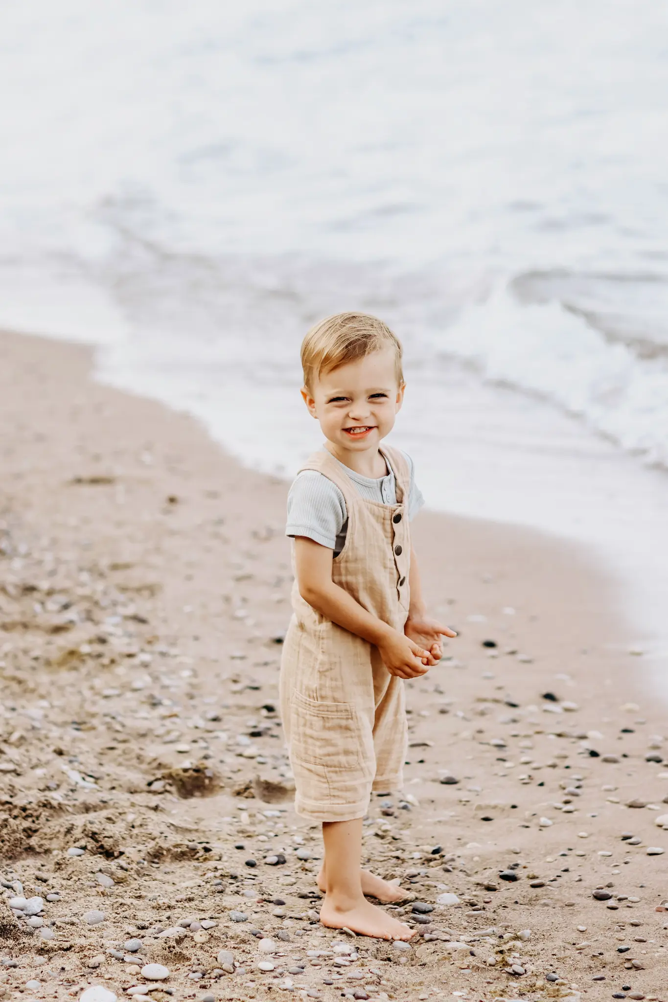 Young child standing on the sand beside the ocean during a Puerto Rico family session, photographed by Olga Thomas