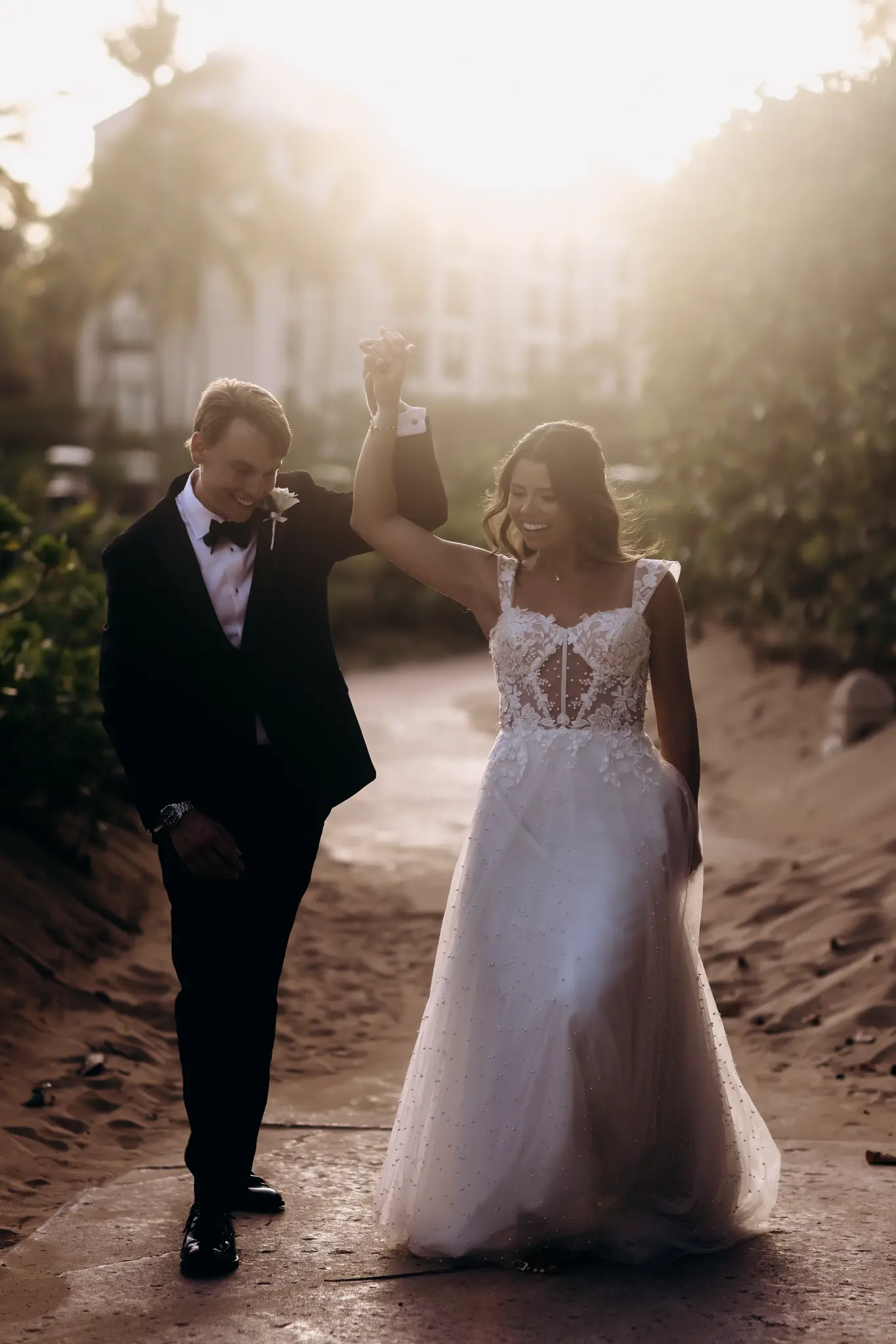 Wedding couple holding hands in warm backlit outdoor light