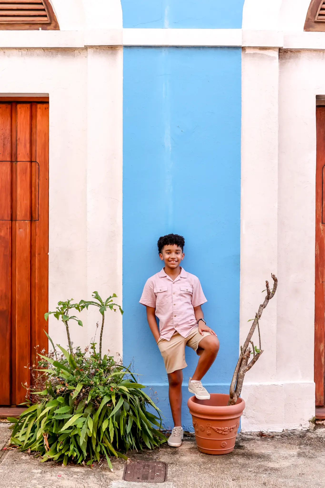 Young boy beside a colorful Old San Juan doorway during a family session, photographed by Olga Thomas