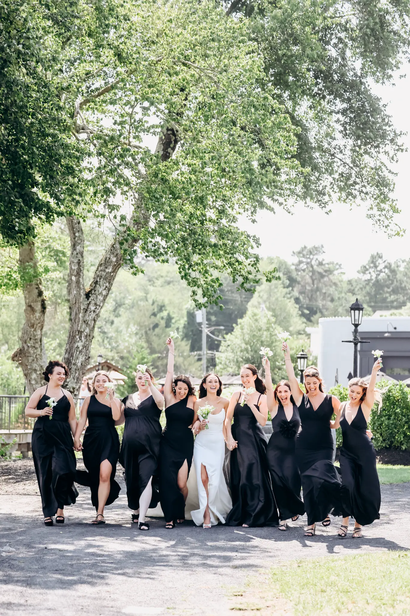 Formal wedding party assembled on a tree-lined path