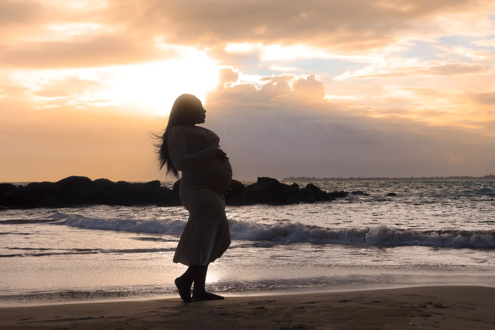 Parent holding a child at sunset during a Puerto Rico beach family session, photographed by Olga Thomas