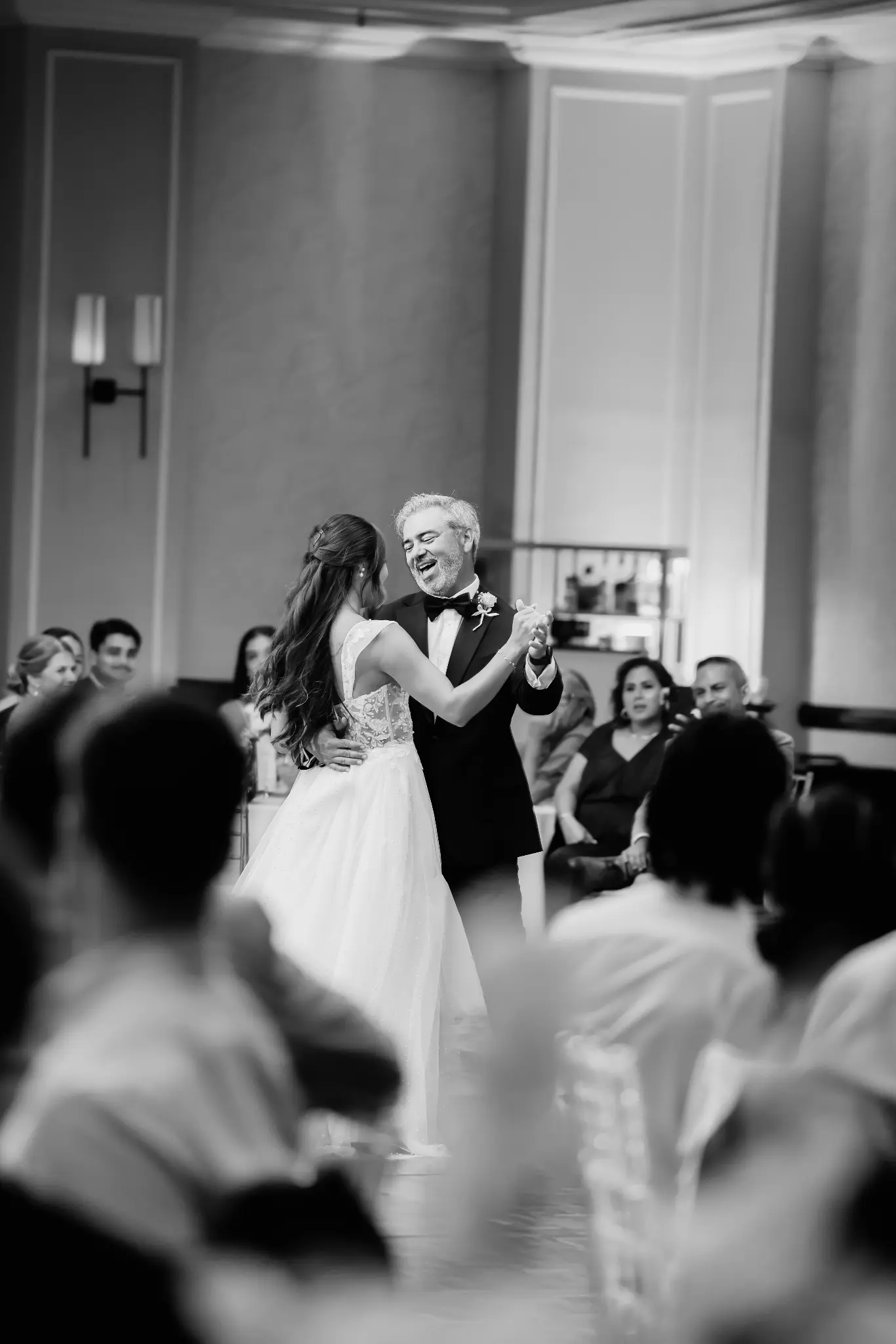 Bride dancing with an older family member as guests watch at the reception