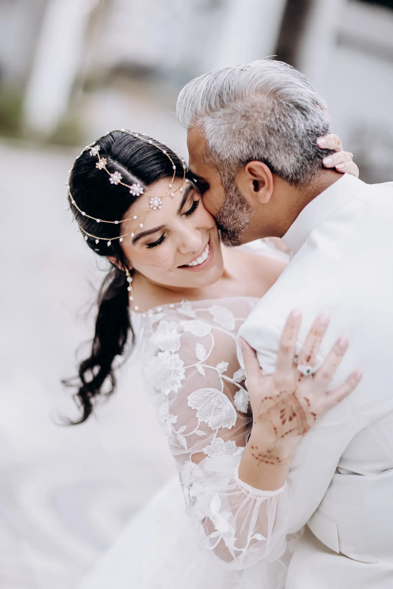 Bride and groom sharing a dance-like embrace beneath a decorative arch