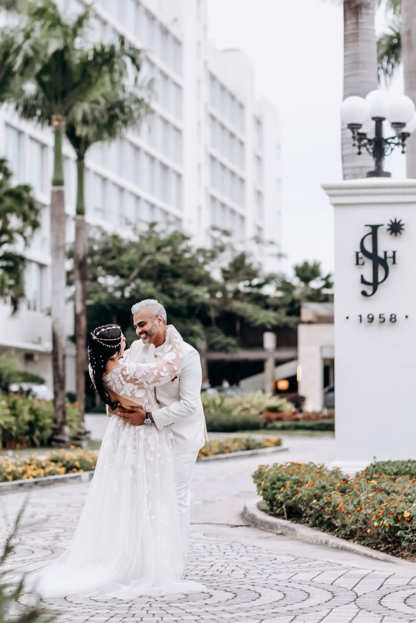Bride and groom standing together near a grand urban facade