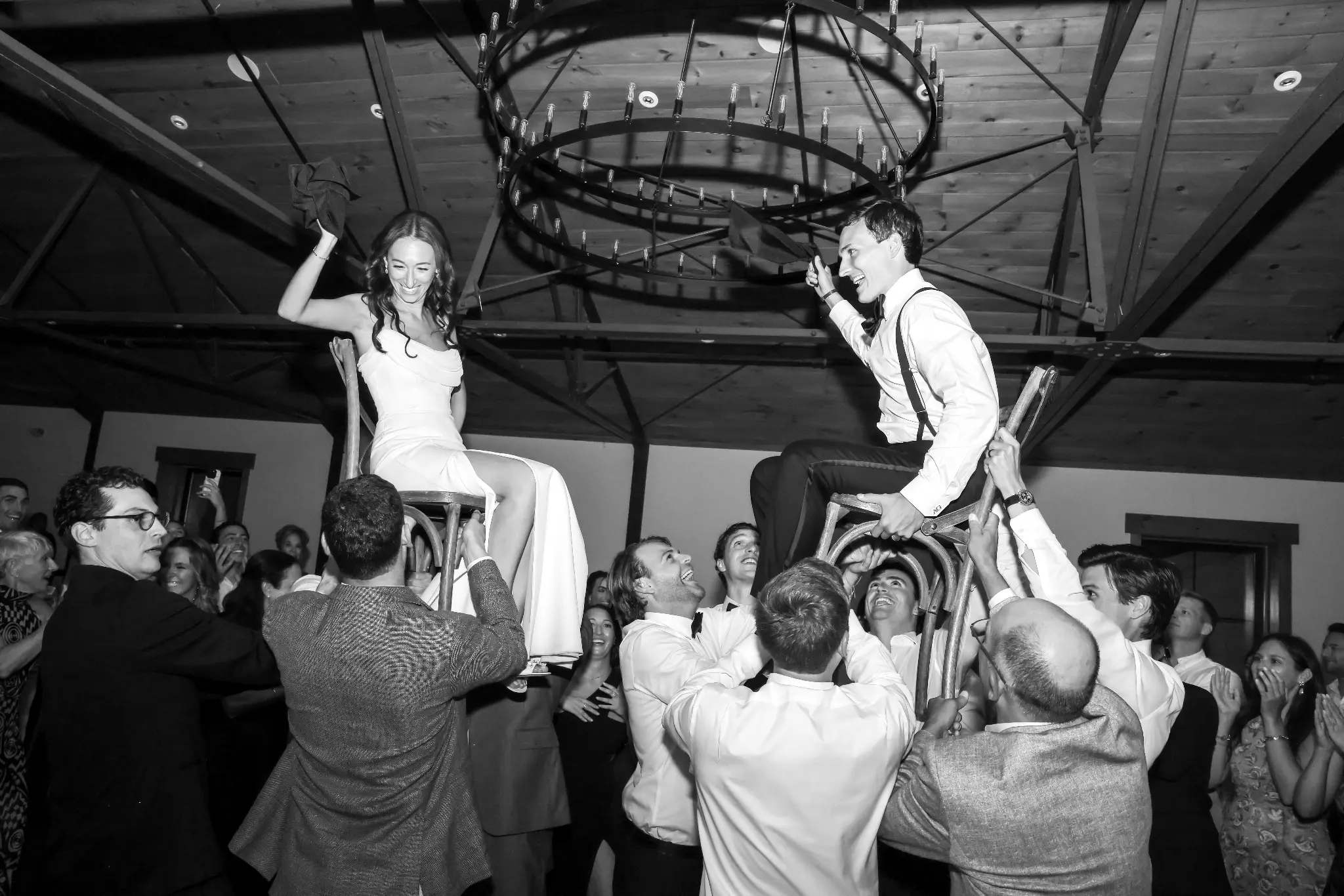 Bride elevated above wedding guests during a lively reception dance