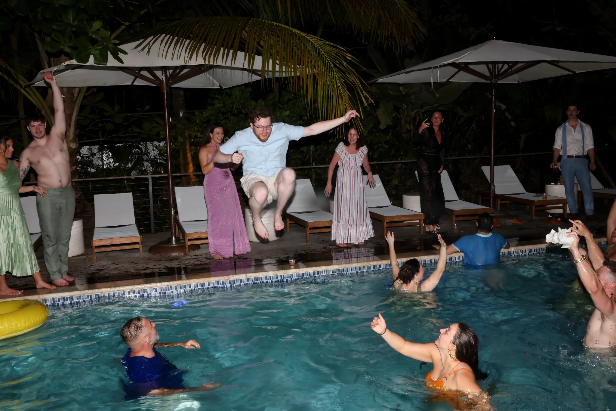 Wedding guests celebrating in a swimming pool during an after-party
