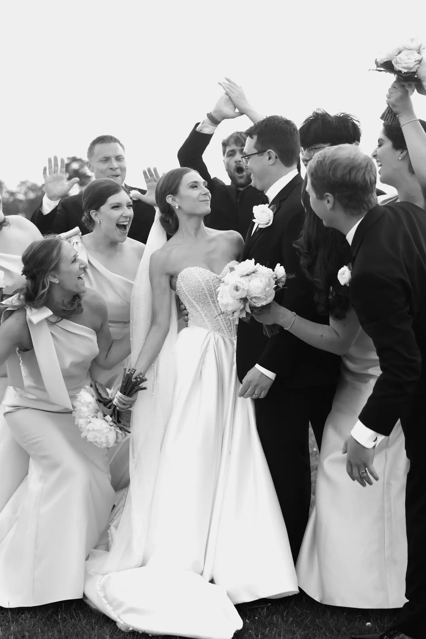 Black-and-white wedding couple surrounded by guests and tossed petals
