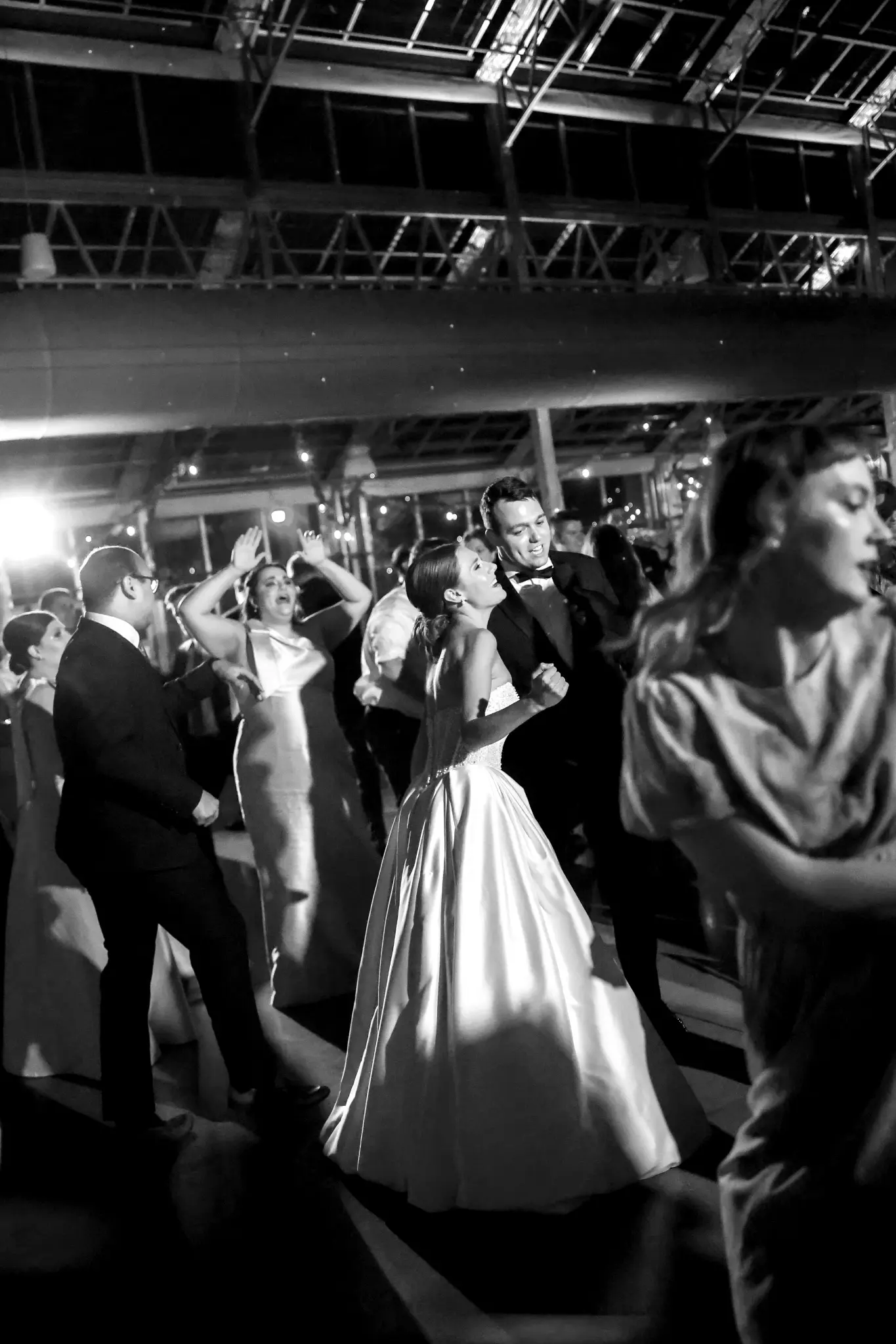 Black-and-white bride dancing in a lively wedding reception crowd