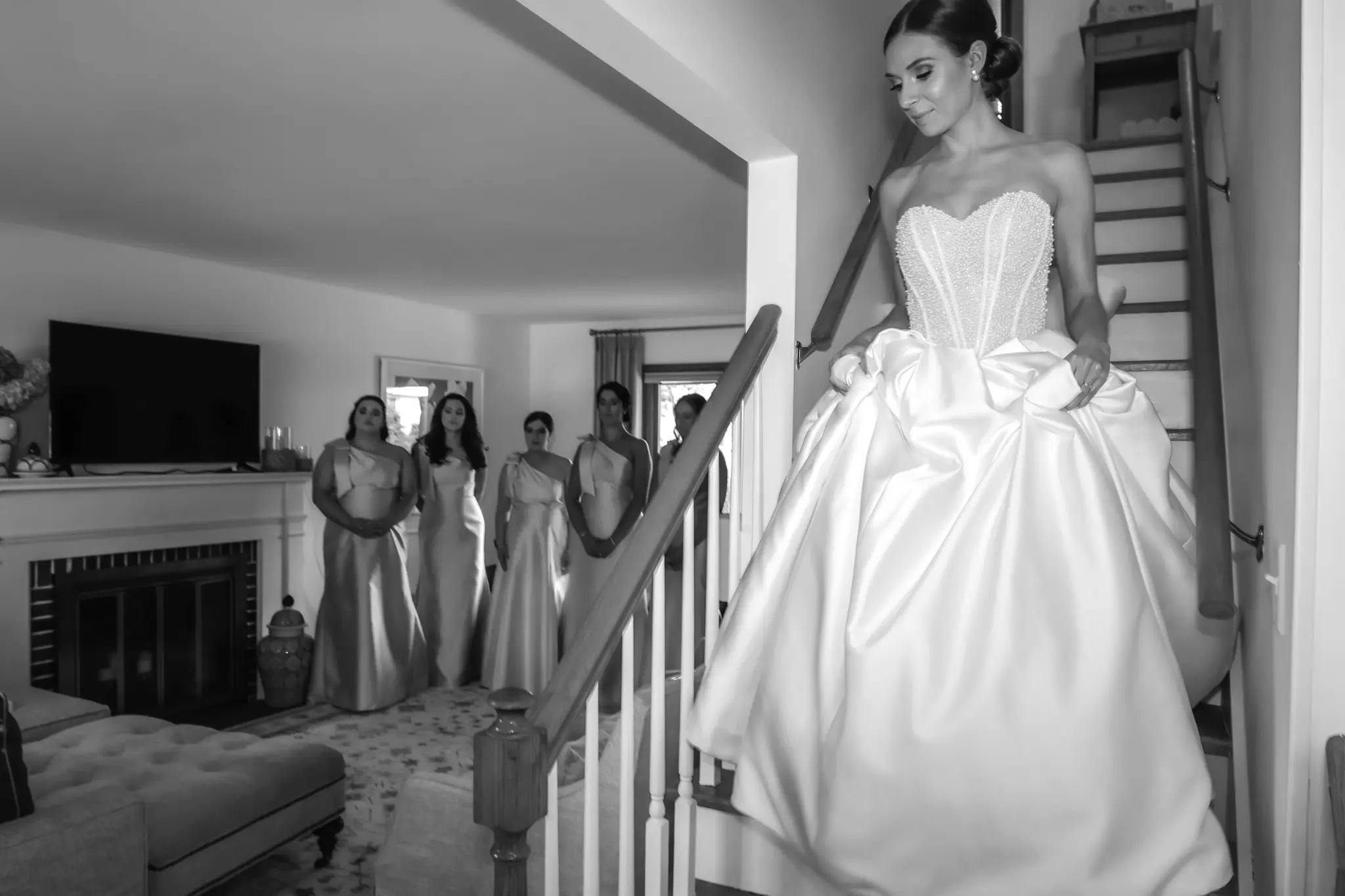 Black-and-white bride descending a staircase with attendants watching before the ceremony
