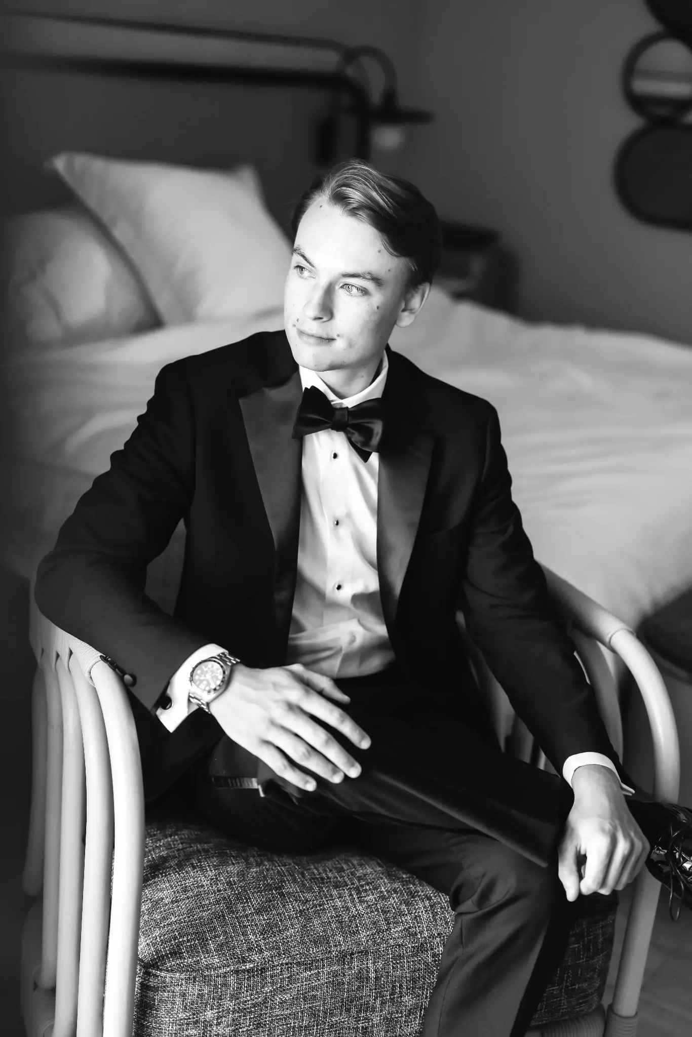 Black-and-white groom portrait in a tuxedo during wedding preparations